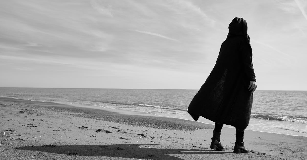  Foto  Grayscale dari Orang  yang Berdiri di  Pantai   Foto  